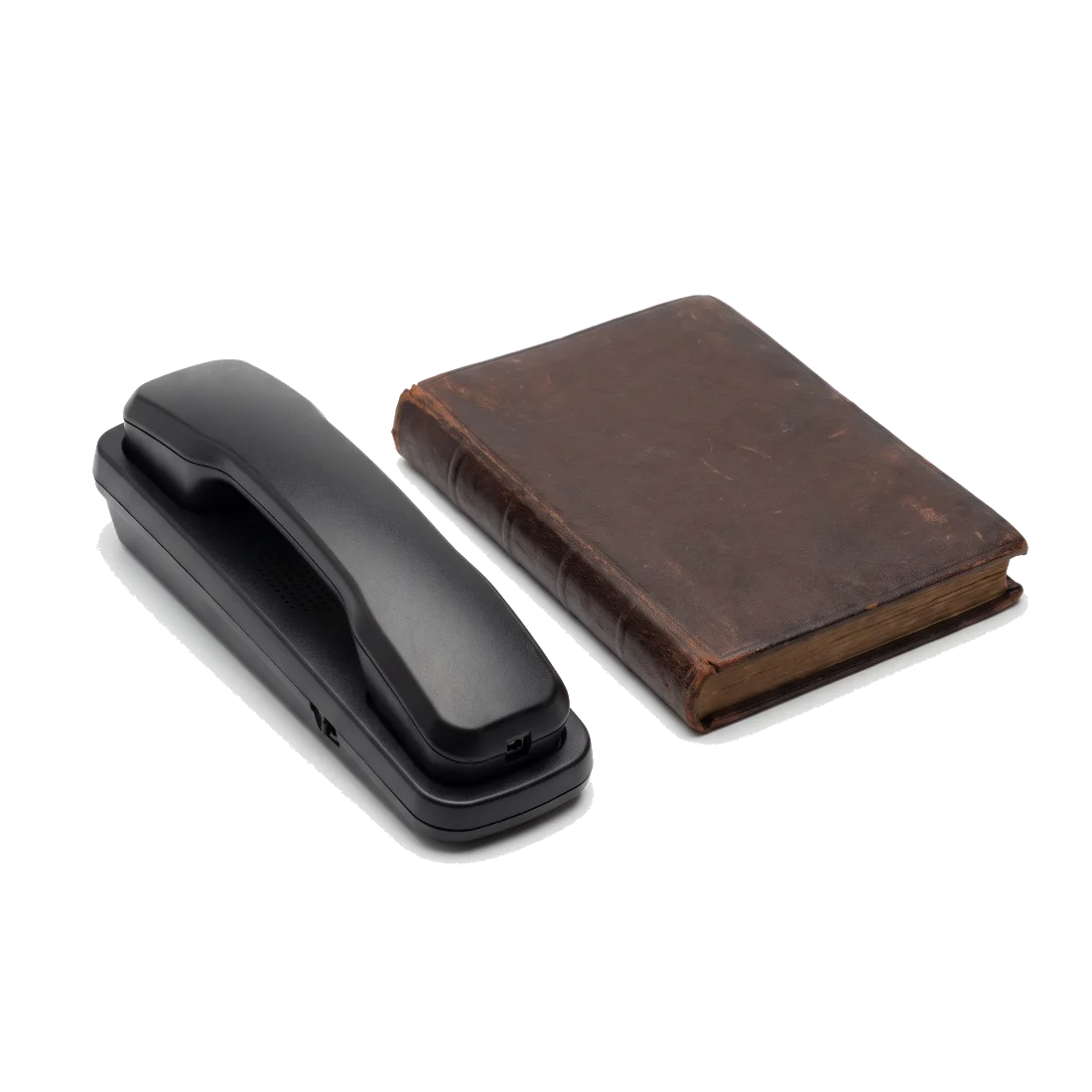 A plain desk telephone handset resting off its cradle beside a closed leather ledger book.