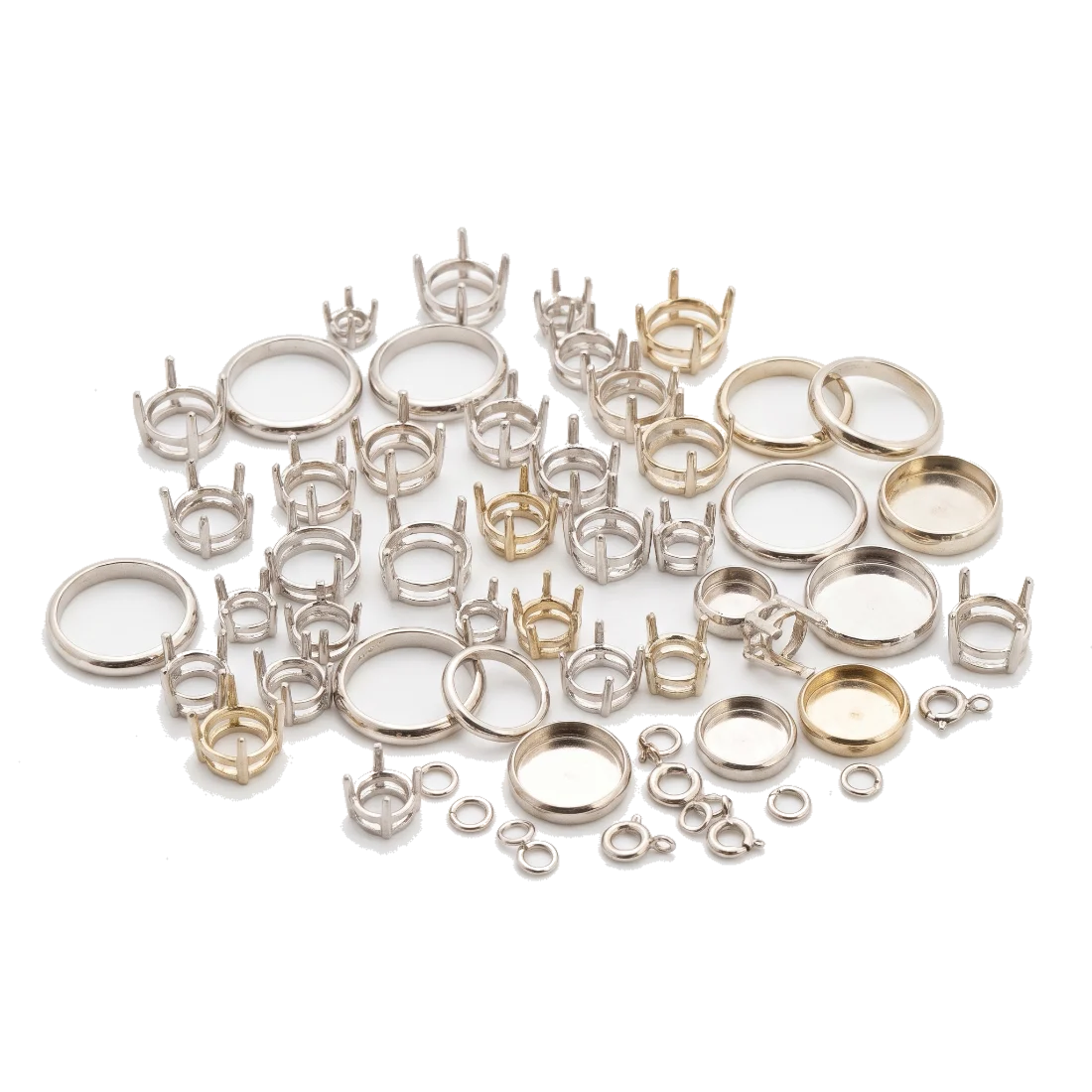 A scattered group of white metal ring mounts and empty claw settings, some cooler white and some faintly warmer in tone.